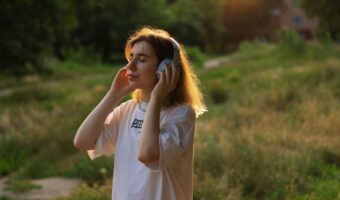 屋外でヘッドホンを使って音楽を聴く女性